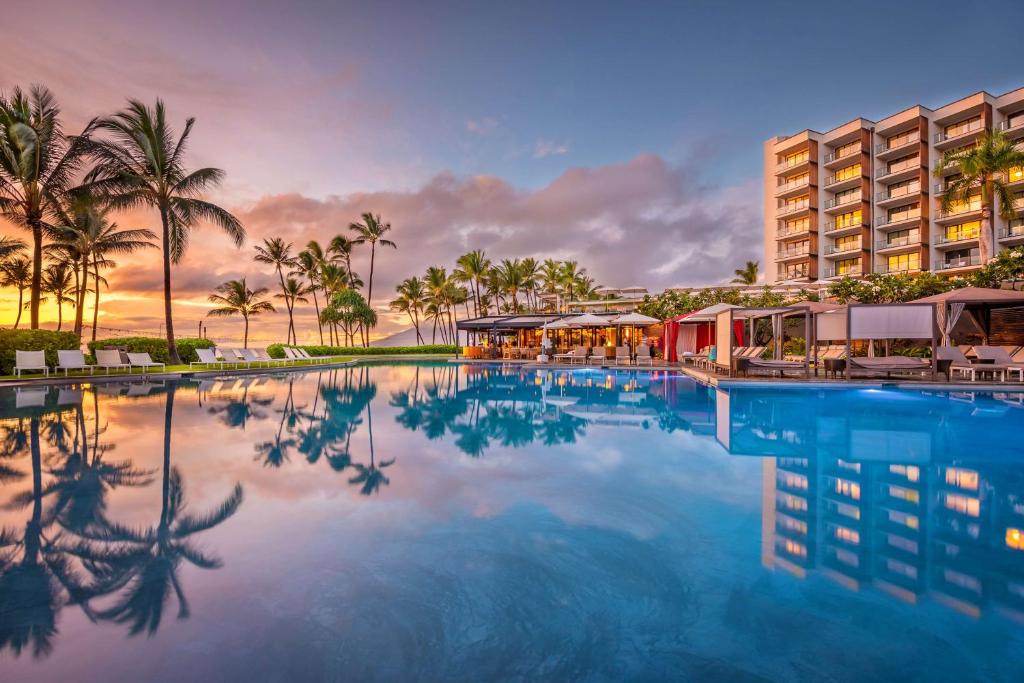 维雷亚凯悦集团威雷亚毛伊岛安达仕酒店的棕榈树度假村的游泳池以及大楼