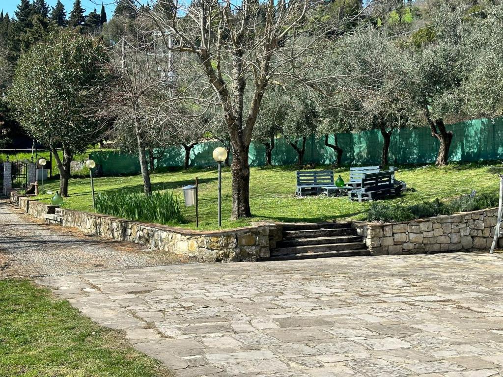蓬塔谢韦Agriturismo Tassinaia的公园里长着长凳、楼梯和树木