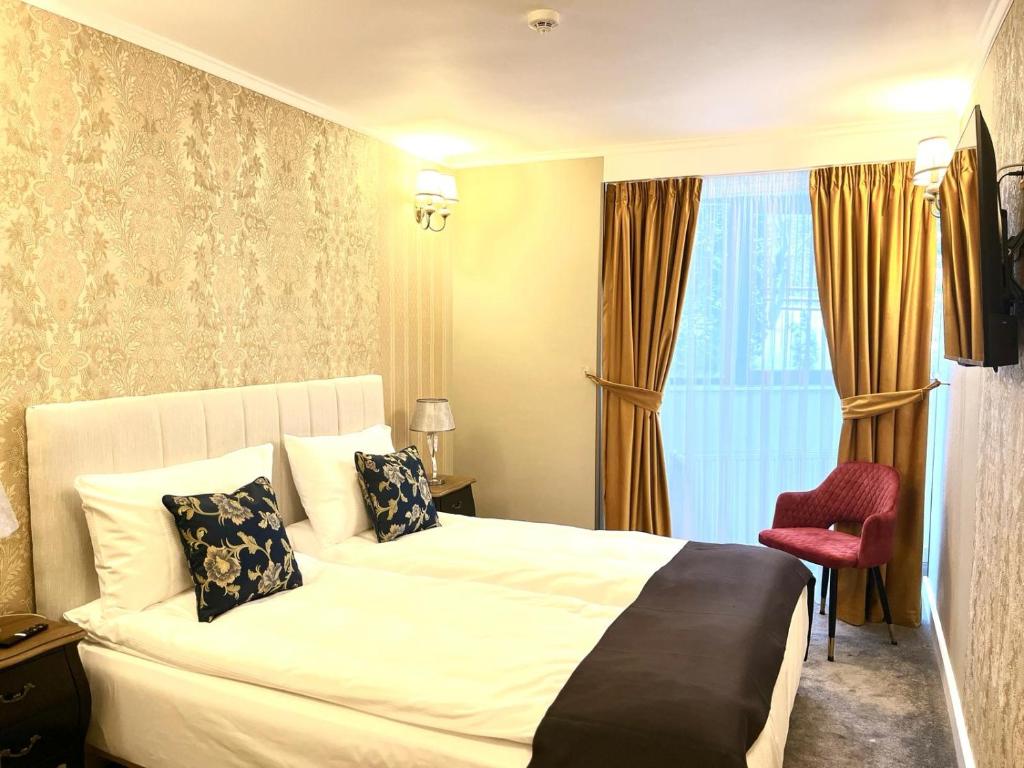 波亚纳布拉索夫Torres Poiana的酒店客房,配有一张床和一张红色椅子