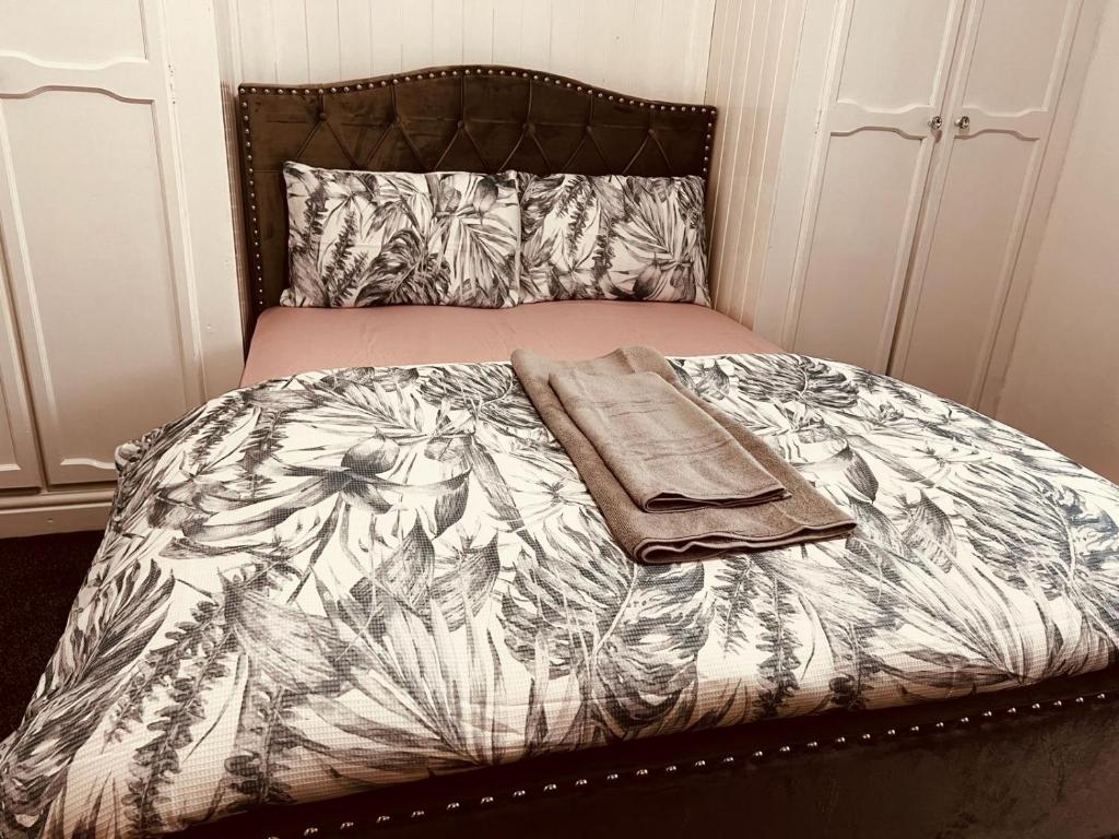 诺丁汉Holiday House Near Football Ground的一张带毯子的床和两张毛巾