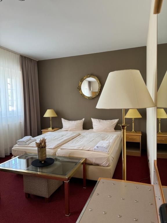 柏林波恩福德（万湖-霍夫）酒店的酒店客房配有一张床铺和一张桌子。