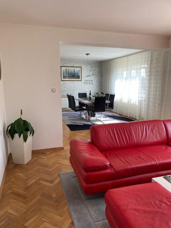 萨格勒布Astralis Factory Apartments- FLY的一间带红色沙发的客厅和一间用餐室