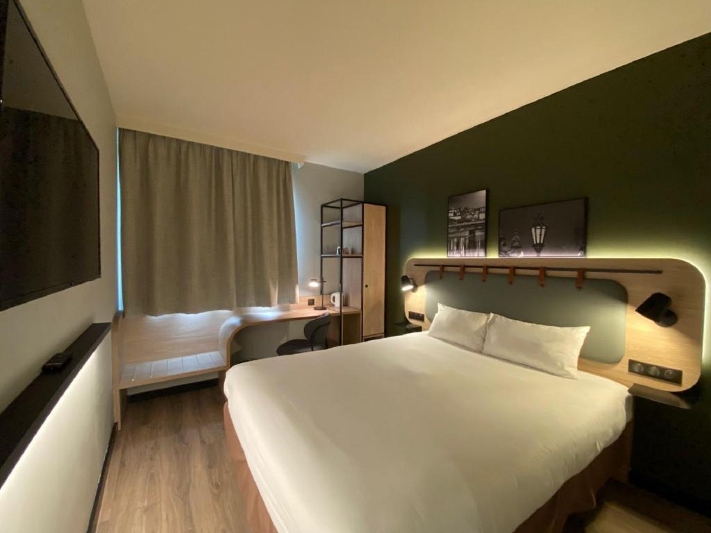 里昂钟楼里昂中央酒店的酒店客房设有一张白色大床和一个窗户。