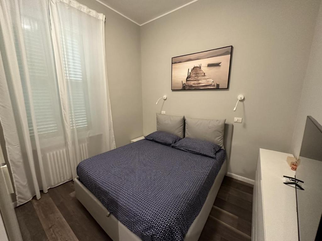 阿拉西奥Nuovo Appartamento Borgo Coscia的一间小卧室,配有一张床和墙上的照片