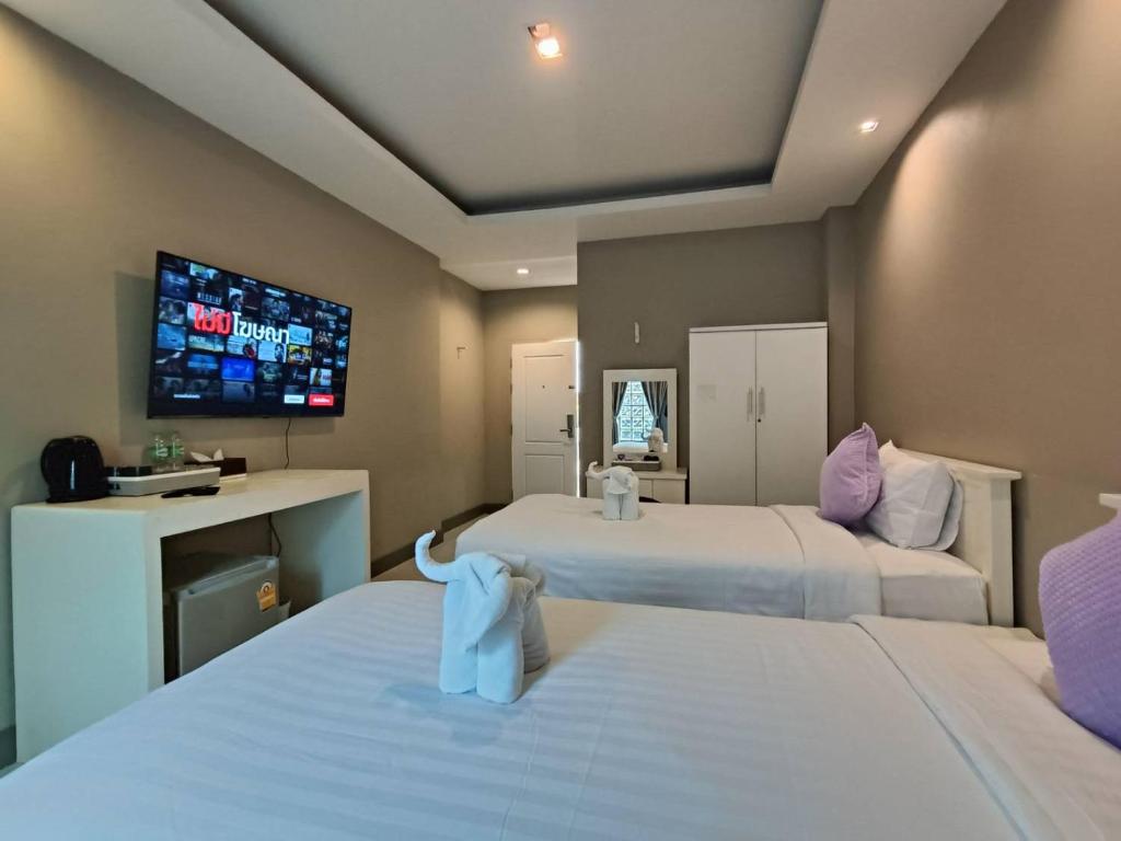 清迈The Guest Chang Moi Hotel的酒店客房设有两张床和一台平面电视。