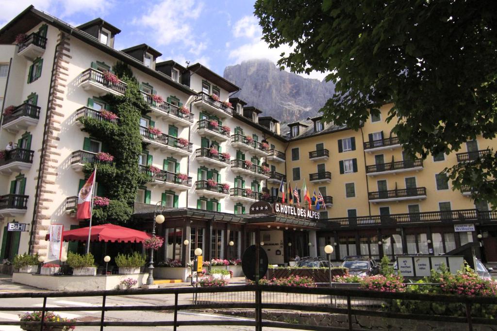 圣马蒂诺-迪卡斯特罗扎G. Hotel Des Alpes (Classic since 1912)的一座酒店,前面有一座鲜花建筑