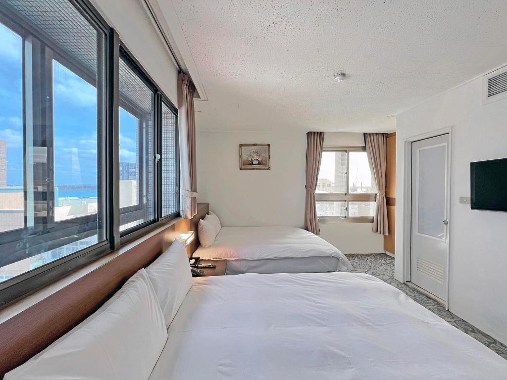 马公丰国大饭店的酒店客房设有两张床和大窗户。