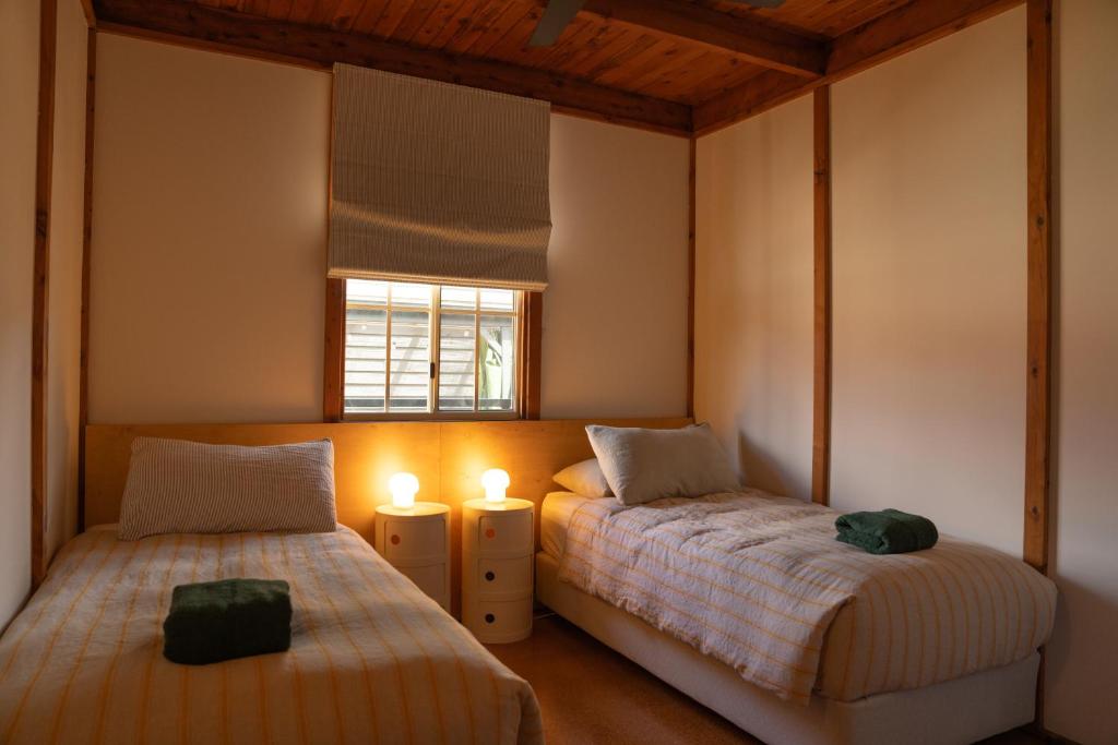 赫斯基森Seahorse Manor, The South Coast Sandcastles的一间卧室设有两张床和窗户。