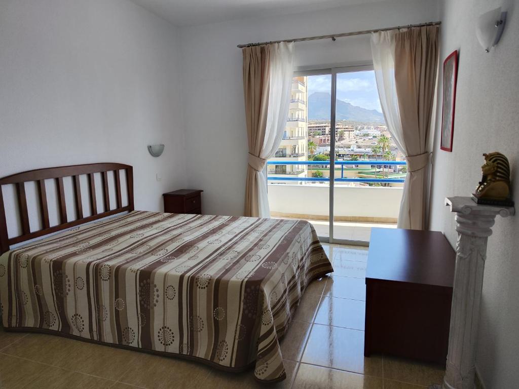 帕莱索海滩Olga Paraiso del Sur的一间卧室设有一张床和一个大窗户
