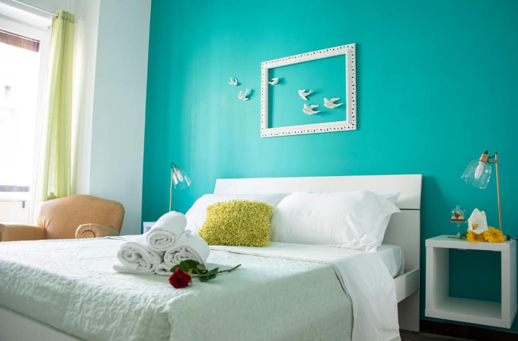 萨莱诺Reginella Guest House的一间拥有蓝色墙壁的卧室和一张带白色床单的床