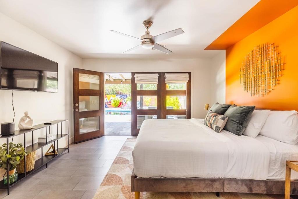 斯科茨Heated Pool Outdoor Kitchen Patio Modern Design的一间卧室配有一张带橙色墙壁的大床