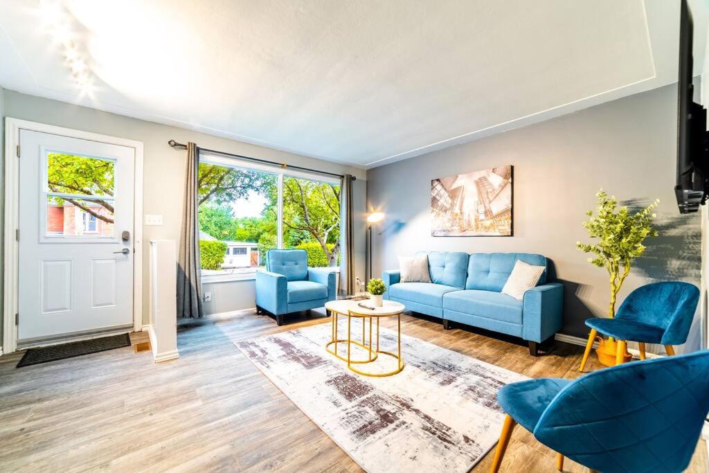 坎布里奇3BD Suite: 5min to HWY 401 - Wifi+Desk+KingBed的客厅配有蓝色的沙发和椅子
