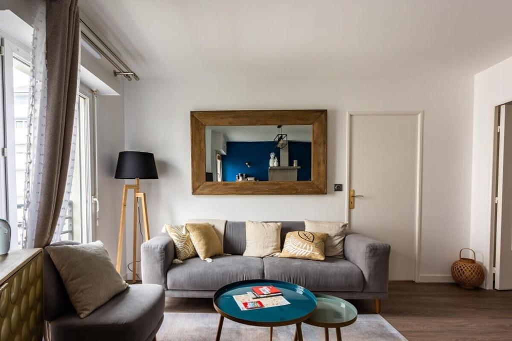 雷恩Le Saint Helier -Appartement Cosy et calme Parking的客厅配有沙发和桌子