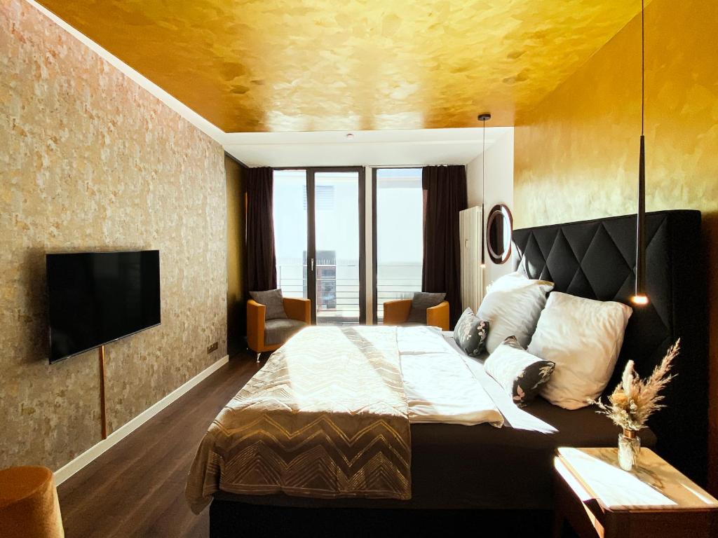莱比锡Exklusives Leipzig City Apartment Sunrise的酒店客房,配有床和电视
