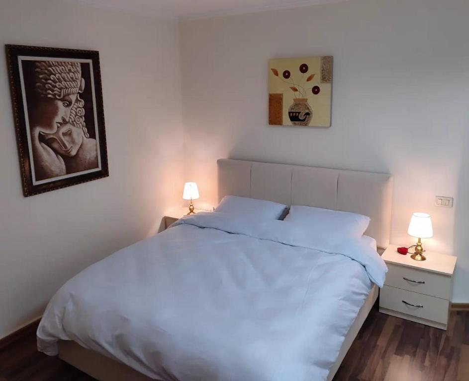 地拉那LB Apartments的卧室配有白色的床和2个床头柜