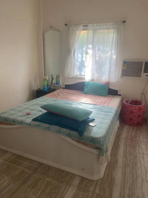 孟买Boho connection的一间卧室配有一张带蓝色枕头的床。