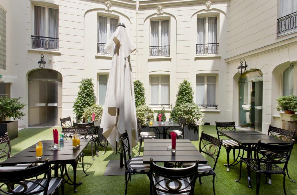 巴黎埃利塞公寓式酒店的一个带桌椅和遮阳伞的庭院
