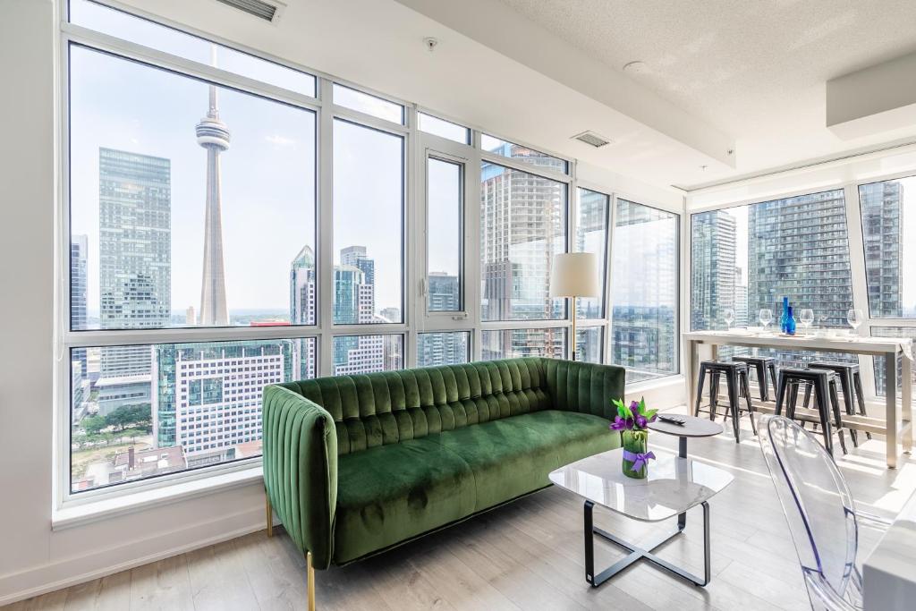 多伦多Executive Suites - Toronto's Entertainment District的客厅设有绿色沙发和大窗户