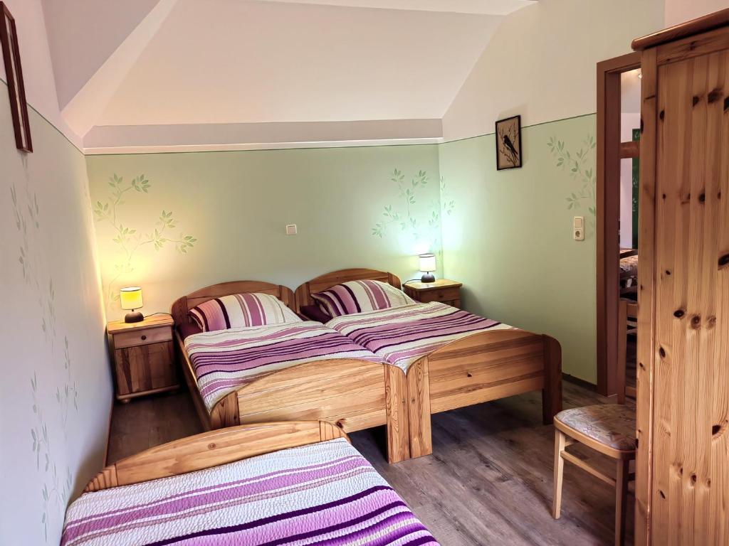 唐格明德Pension Claudia Güldenpfennig的配有绿色墙壁和木地板的客房内的两张床