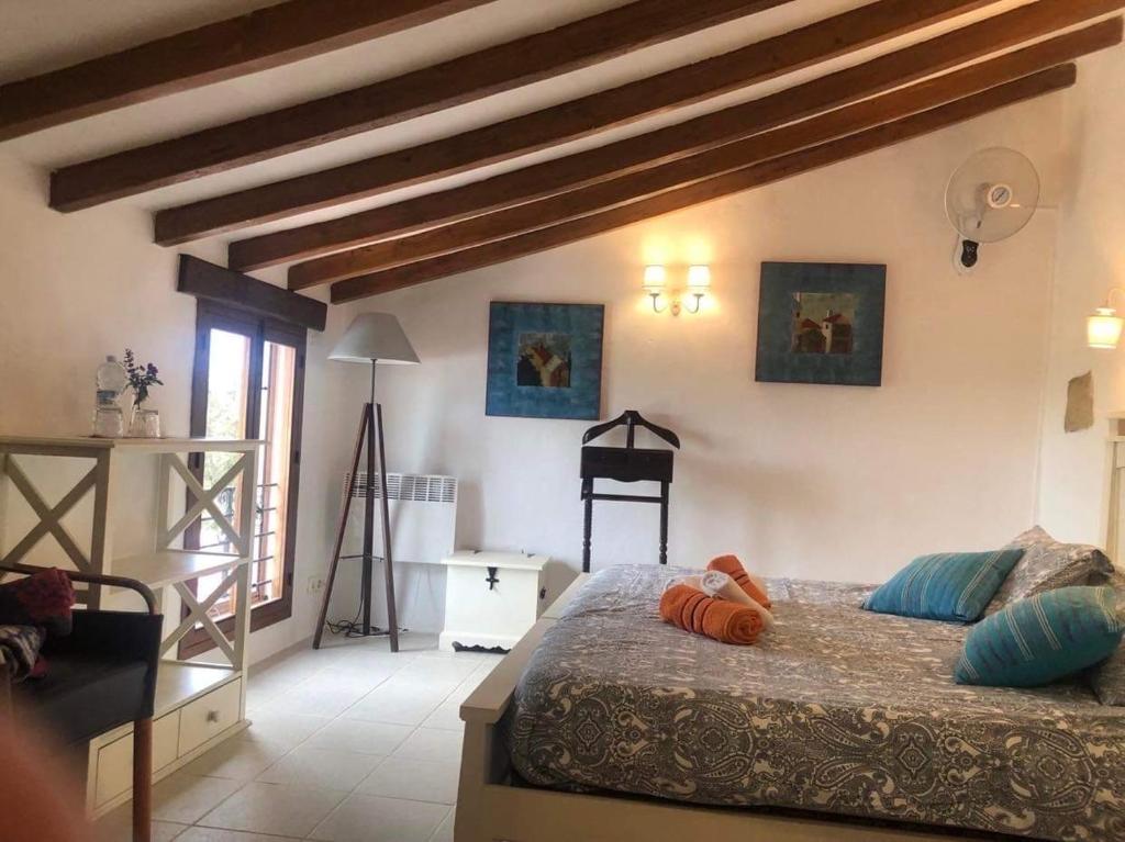 康塞普西翁新镇Finca amorosa的卧室配有一张床铺,位于带木梁的房间