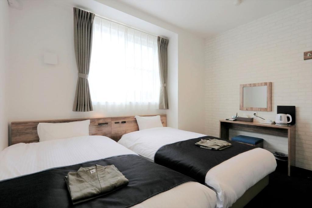 土岐市Yorimichi no Yado - Vacation STAY 37453v的酒店客房设有两张床和窗户。