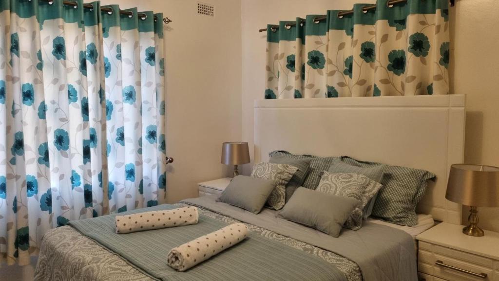 哈拉雷Modern and Stylish 2-Bed Cottage in Harare的一间卧室配有一张带两个枕头的床