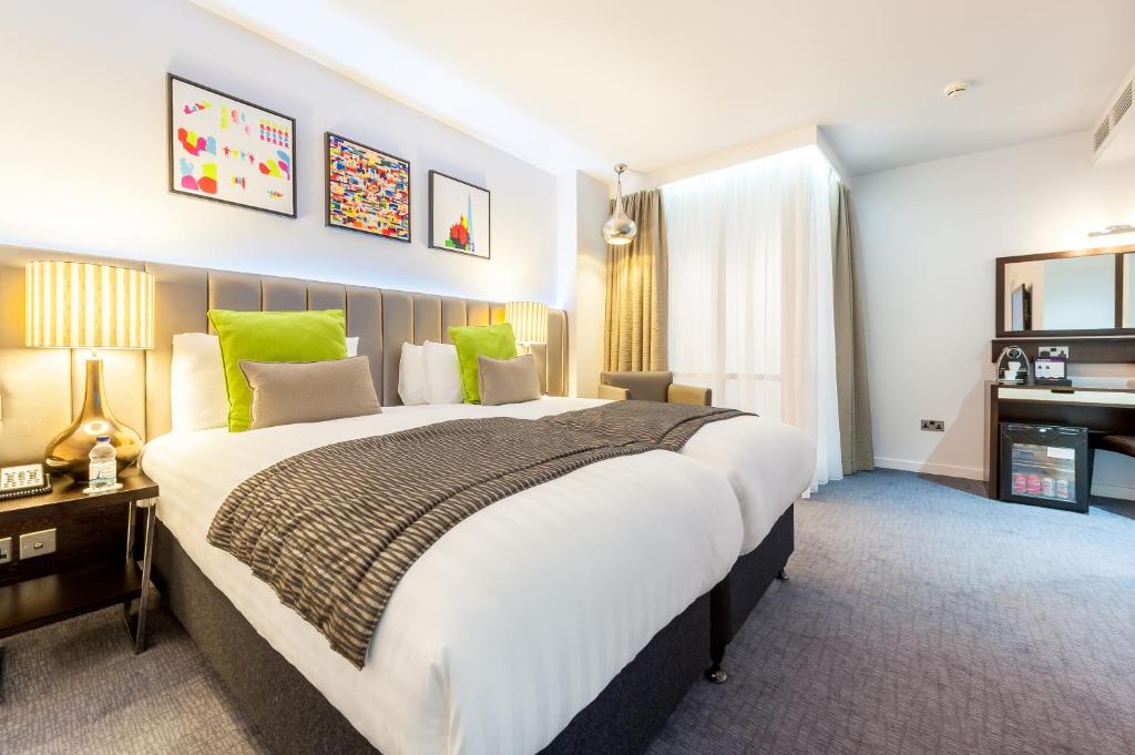伦敦伦敦帕丁顿美居酒店的一间卧室配有一张绿色的大床