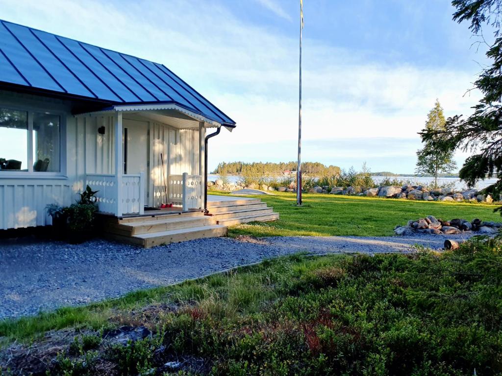 RobertsforsStuga med havsutsikt的蓝色屋顶的白色小房子