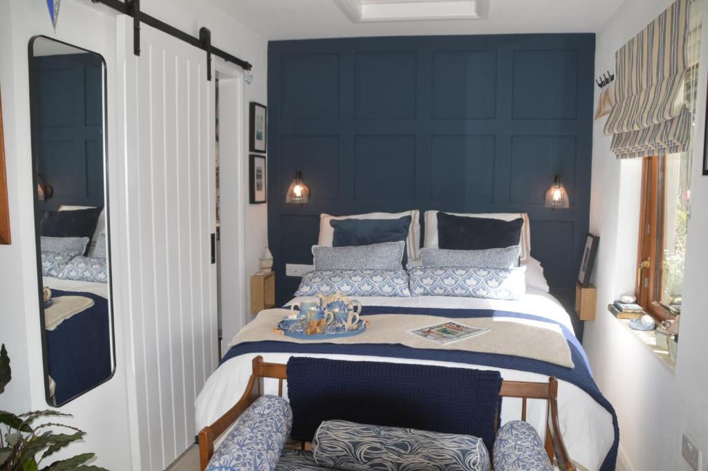 波塔费里Ropewalk Cottage - A Little Treasure By The Coast的一间卧室配有一张大床和蓝色床头板