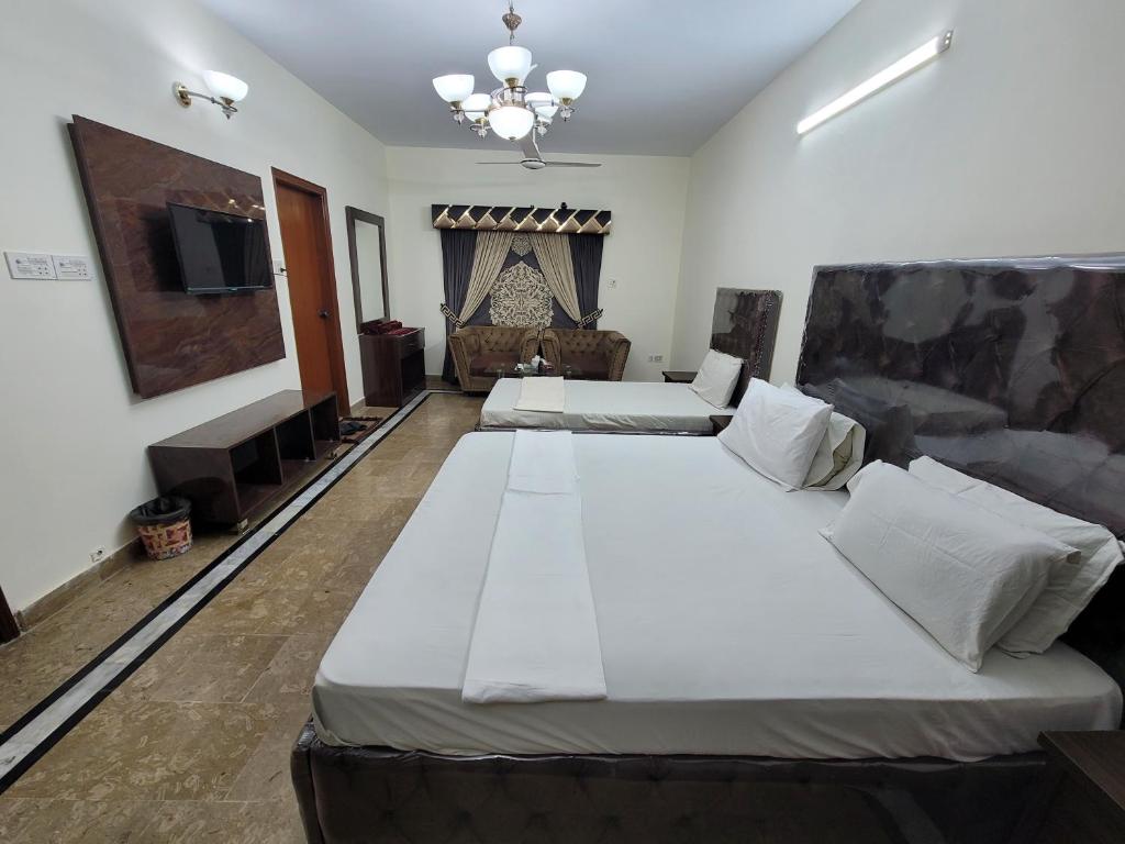 卡拉奇Hotel Capital one的一间卧室配有两张床和一台平面电视