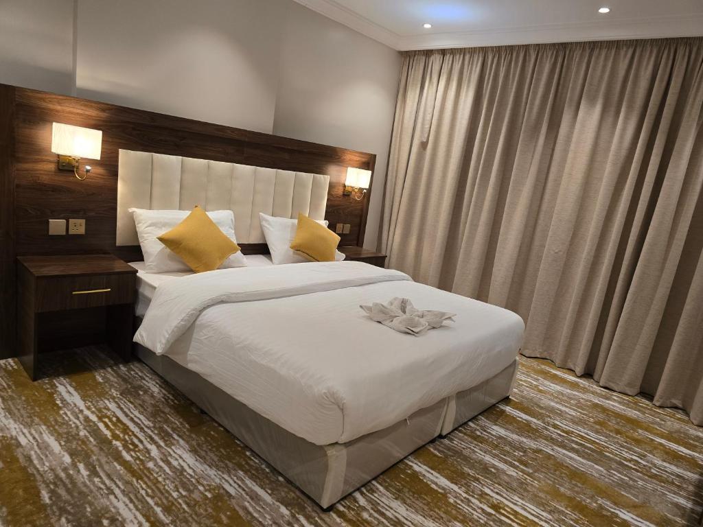 吉达سحابة الأحلام - Dream Cloud Hotel的卧室配有一张带黄色枕头的大型白色床。