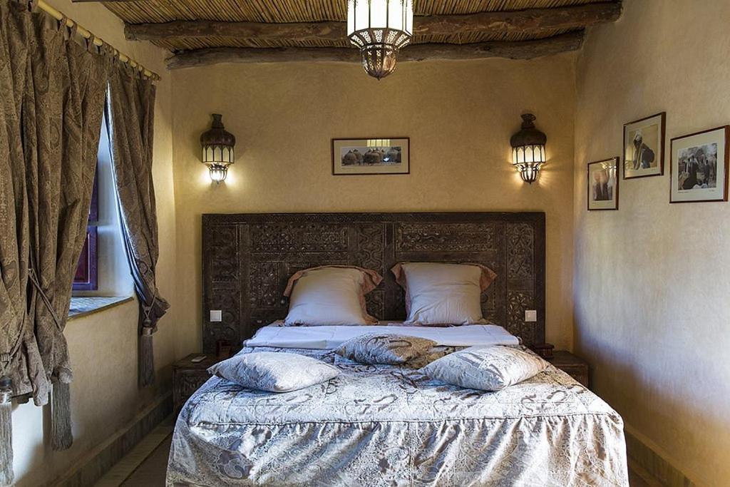 El ArbaRiad des 1001 Fleurs的一间卧室配有带枕头的床