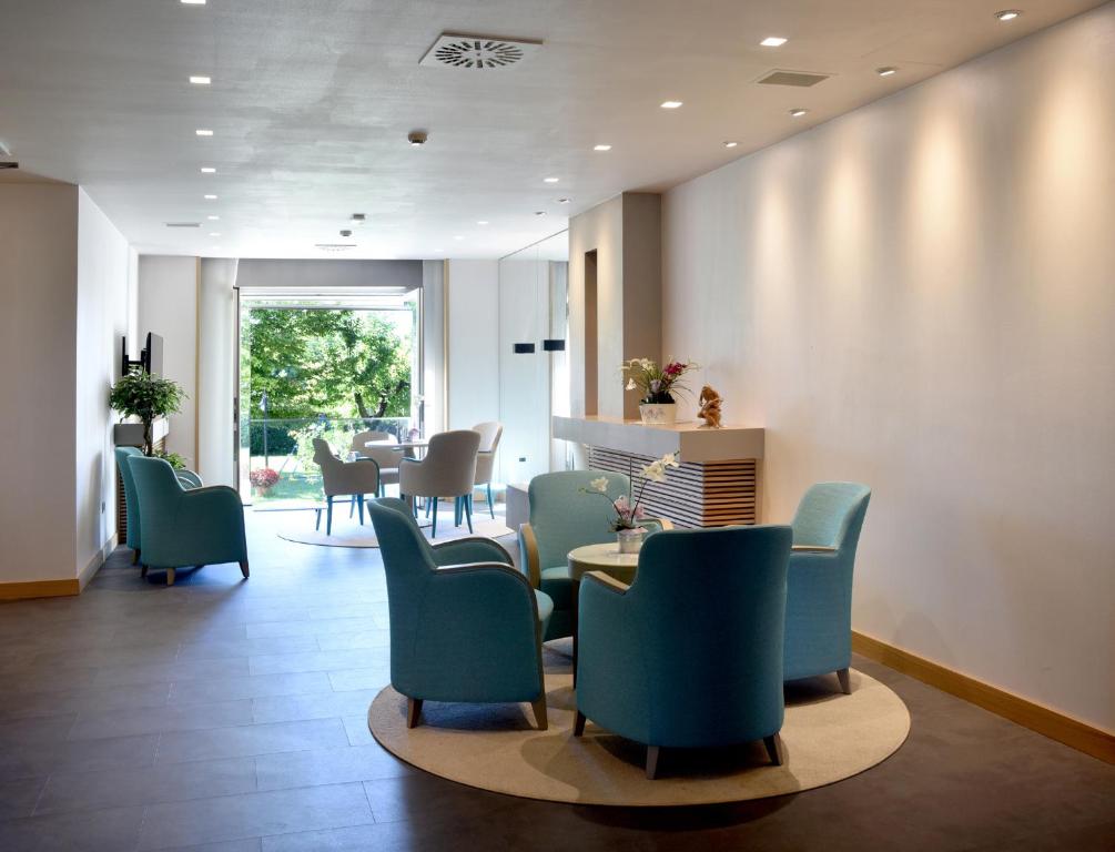 蒙法尔科内意大利酒店的一间设有蓝色椅子和桌子的等候室
