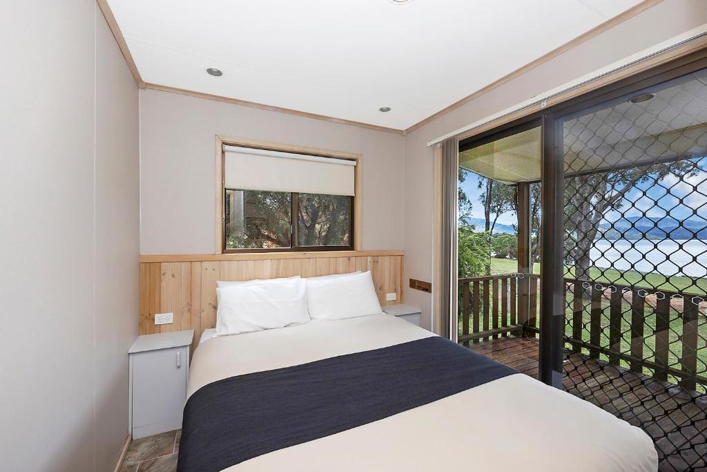 BiggaReflections Grabine Lakeside - Holiday Park的一间卧室设有一张床和一个阳台