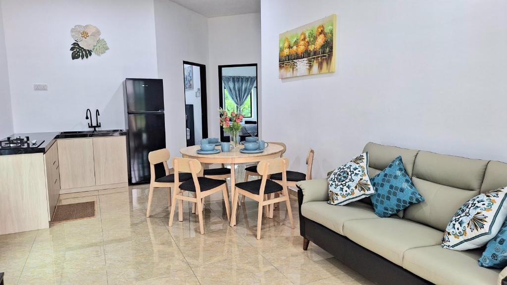 Kampung MawarOcean Cottage 1, Radiant Teluk Sari的客厅配有沙发和桌子