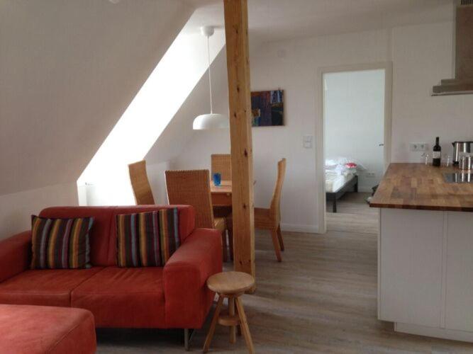 吕讷堡Holiday apartment LueneCastle的一间带红色沙发的客厅和一间厨房