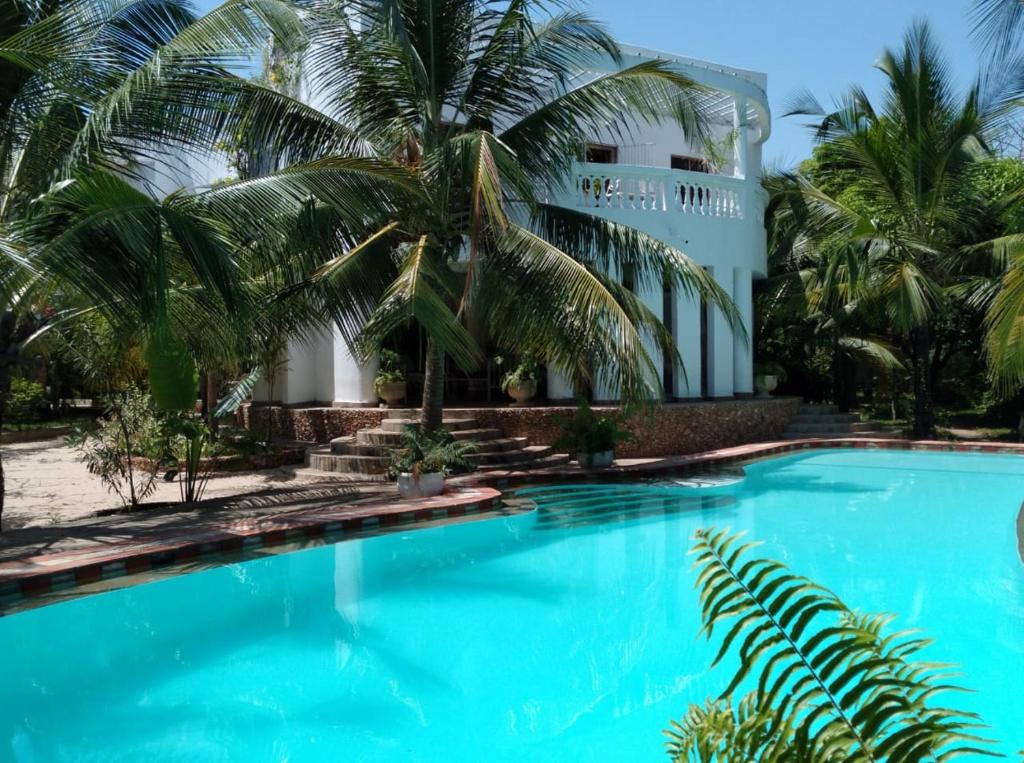 马林迪Mwezi Nyota的一座楼前棕榈树游泳池