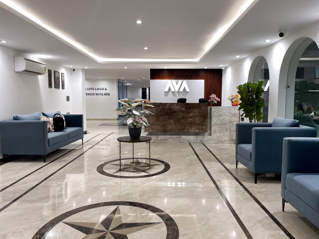 古尔冈AVA Hotels and Corporates Millennium City的一个带沙发和桌子及标志的大堂
