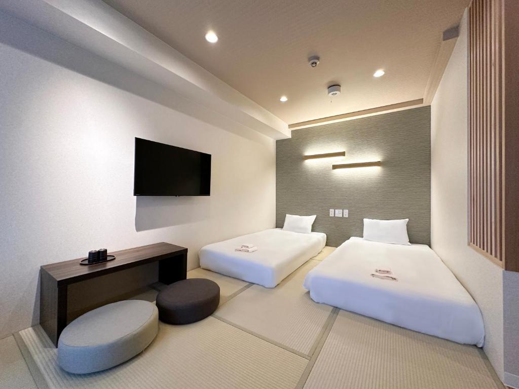 大阪大阪惠比寿酒店的一间酒店客房,设有两张床和电视