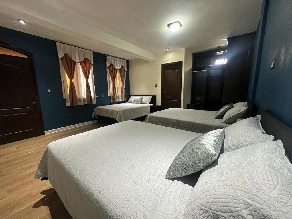 圣胡安拉拉古纳CASA DE DESCANSO TZANJAAY的酒店客房,设有两张床和蓝色的墙壁