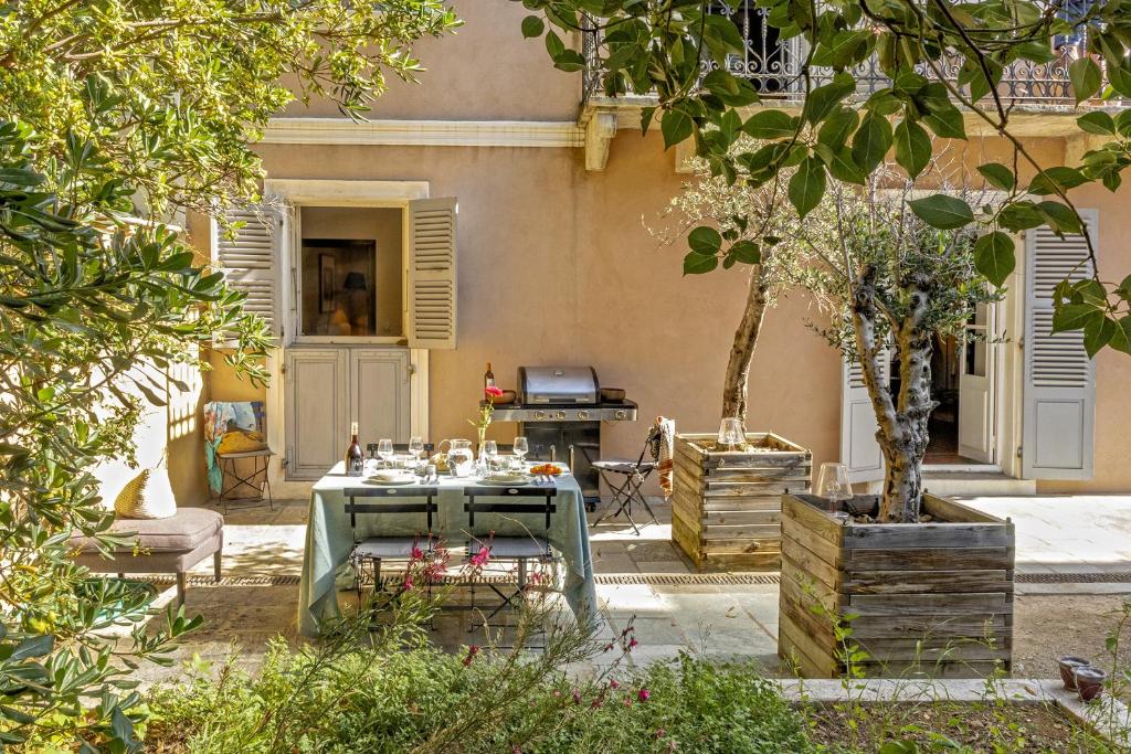 布伦德Villa les Roses的一个带桌椅和烧烤架的庭院
