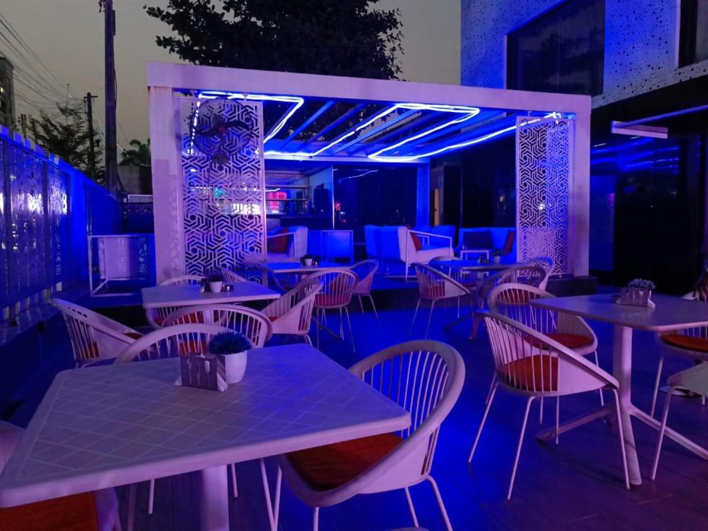 拉各斯Jada Lifestyle & Lounge的一间带桌椅和蓝光的餐厅