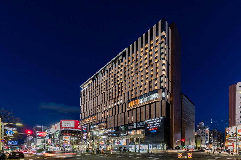 札幌SAPPORO STREAM HOTEL的夜幕降临的城市街道上一座高楼