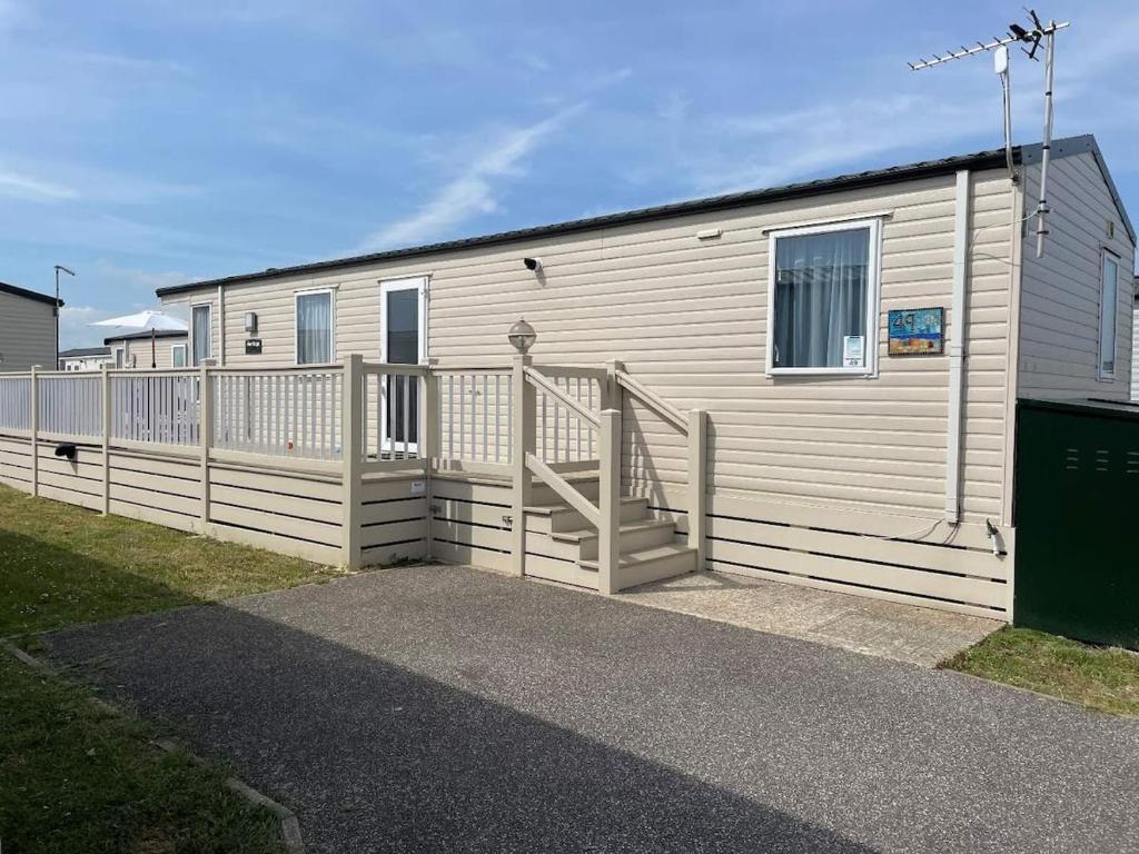 佩文西49 Bayside Cove Pevensey Bay Holiday Park的一座设有楼梯的建筑,靠近栅栏