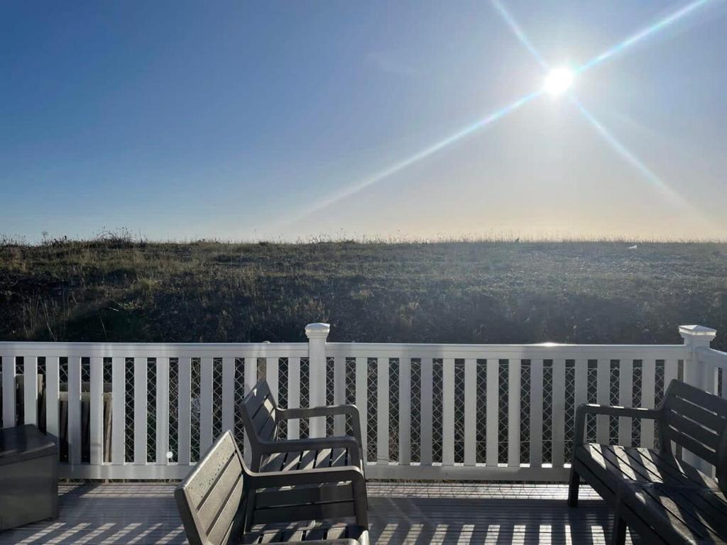 佩文西74 Bayside Cove Pevensey Bay Holiday Park的两把长椅,在天空中晒太阳