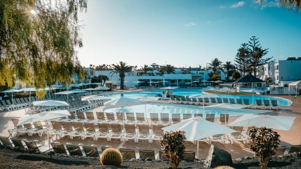 科拉雷侯罗伯斯海湾拉布兰达酒店的一个带游泳池、椅子和遮阳伞的度假村