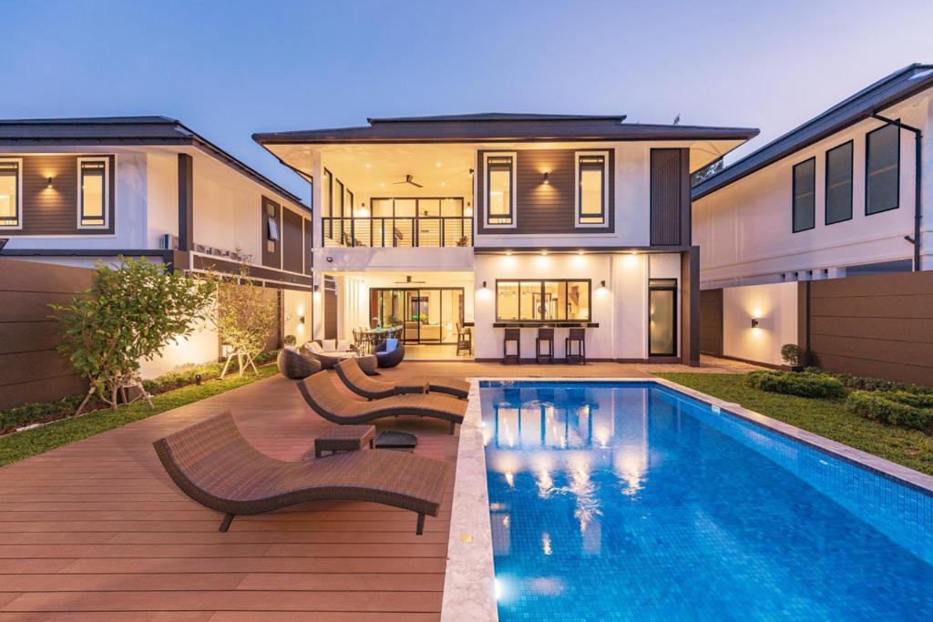 清迈清迈•印象1号市区长康路附近高端豪华泳池别墅Pool Villa Chiangmai的房屋前有游泳池的房子