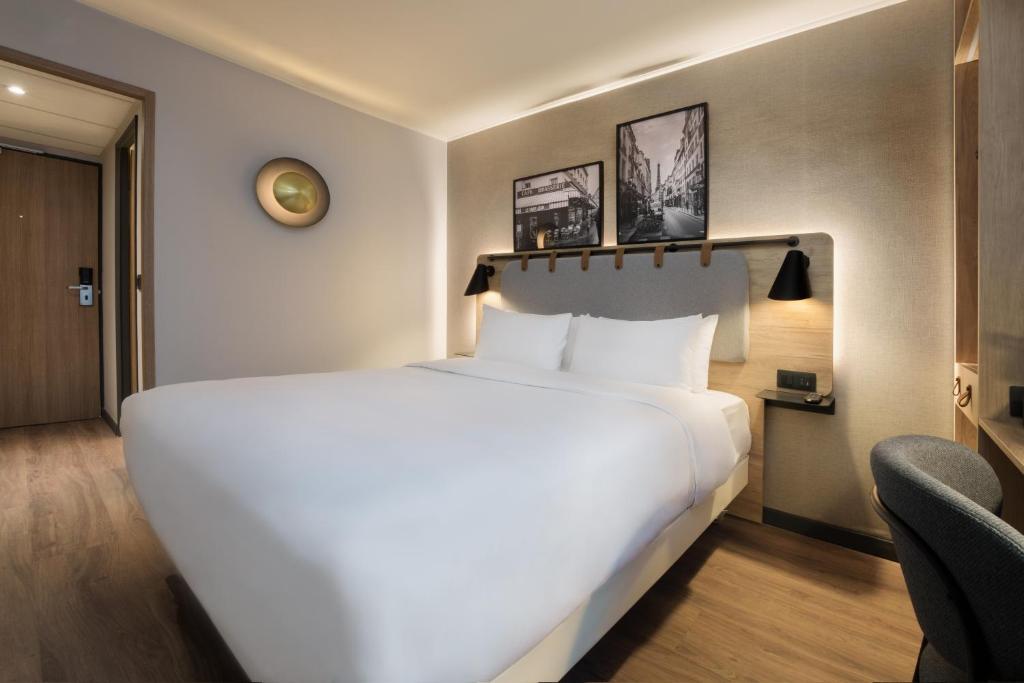 尼姆钟楼尼姆中央玛加博内尔酒店的一张大白色的床,位于酒店客房内
