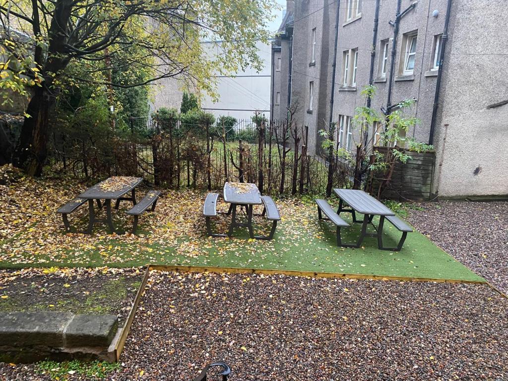斯特灵Hamish Apartment的庭院里一组野餐桌和长凳
