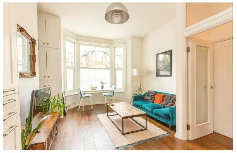 伦敦Stylish, 2 Bed Apartment, Muswell Hill的客厅配有蓝色的沙发和桌子